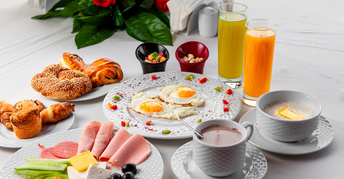 High angle view delicious breakfast in table with salad, fried eggs and pastry on white background. horizontal